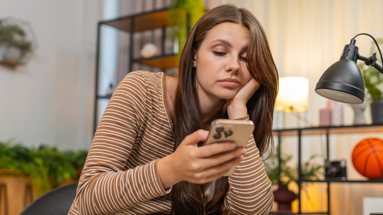 Woman unhappily looking at her phone