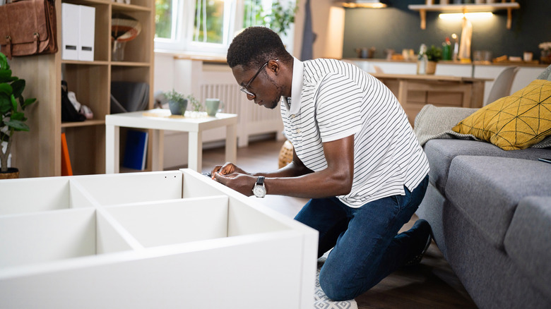 Man assembling cubby system in his apartment