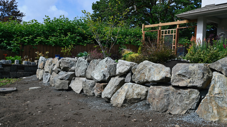 Boulder retaining wall in front of a house