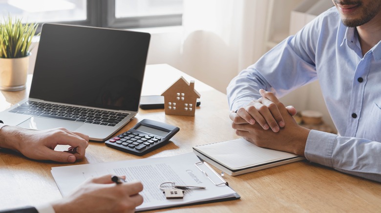 Two people discussing loan papers