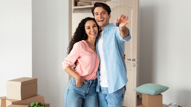 Couple holding keys to home