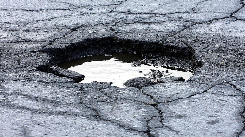 A pothole in asphalt filled with water