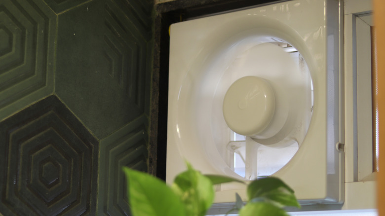 Exhaust fan in a modern green tile bathroom