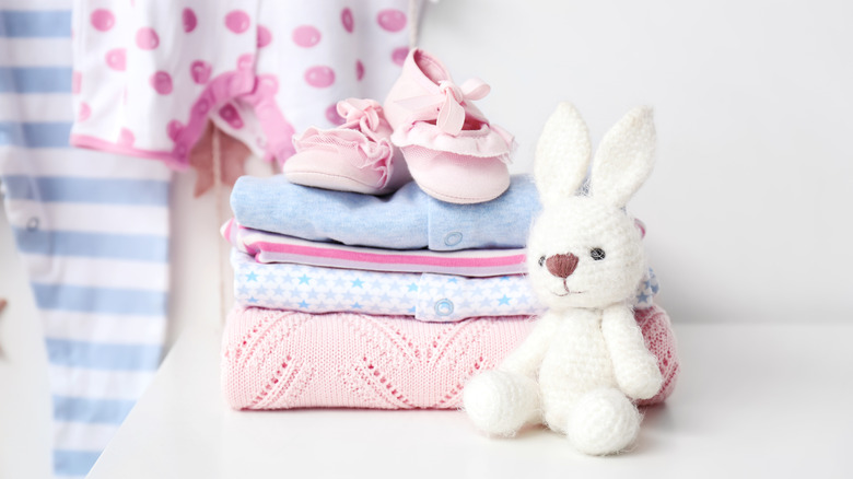 folded baby clothes with toy