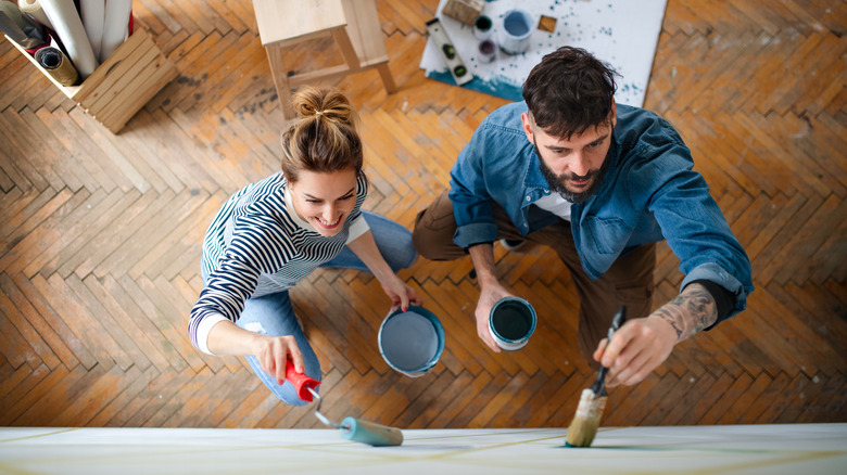 Couple painting a wall