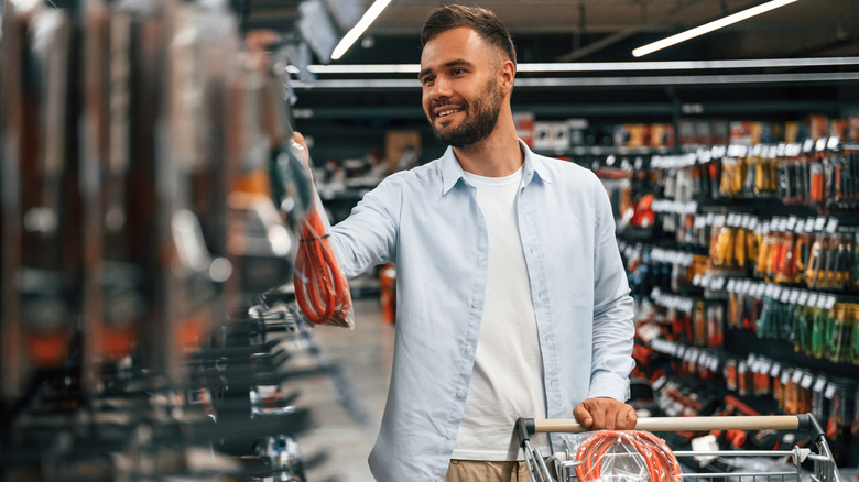 man at the hardware aisle shopping for tools and gadgets