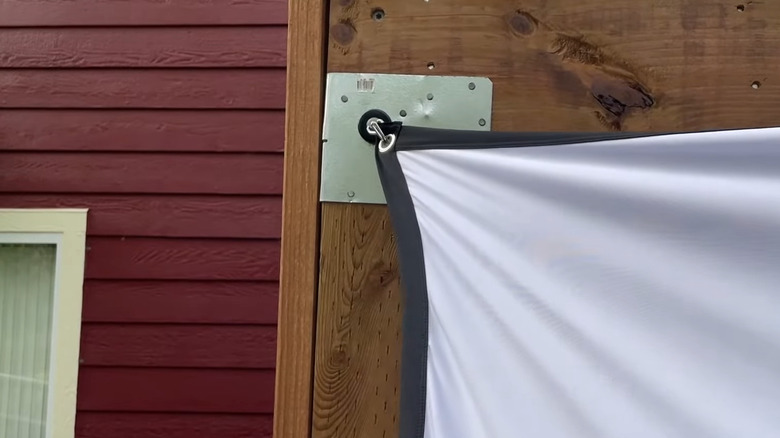 a rotating magnetic hook positioned on a metal bracket makes it easy to mount a tarp or banner