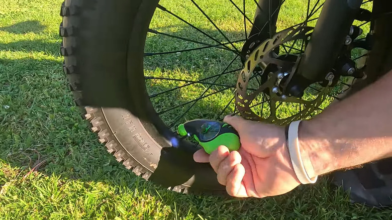 using a Slime digital tire pressure gauge to see exactly how much pressure is in your tire