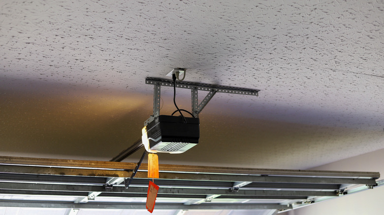 A ceiling-mounted garage door opener as seen from inside a garage.