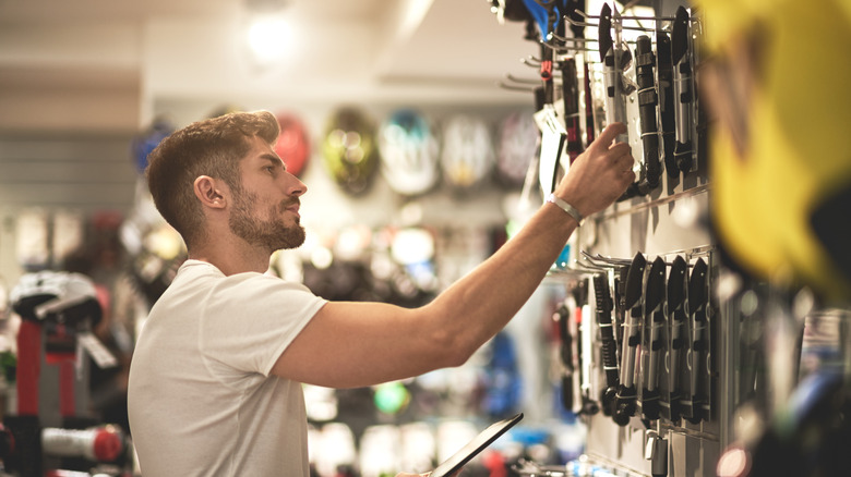 Man in white T-shirt shopping for tools in a hardware store