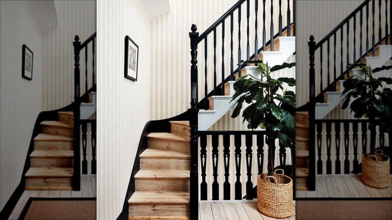 Striped wallpaper is behind a large black staircase