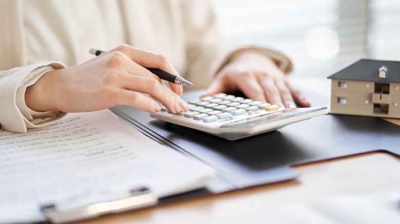 person with pen and calculator
