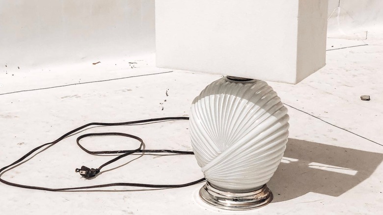 A ceramic white lamp with a pleated, shell design