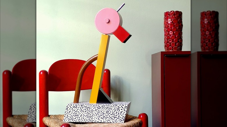A Tahiti lamp with pink, red, black, brown, and white accents sitting on a chair