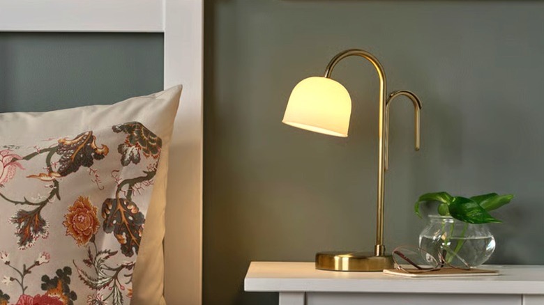 TVÅMASTAD lit up on a nightstand near a bed
