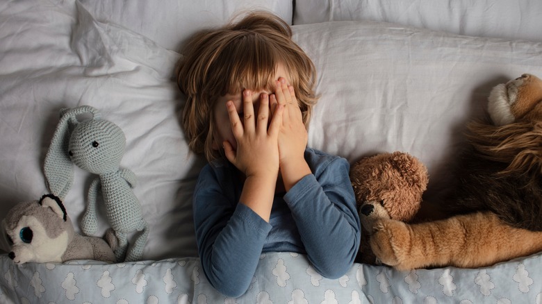 young boy laying in bed