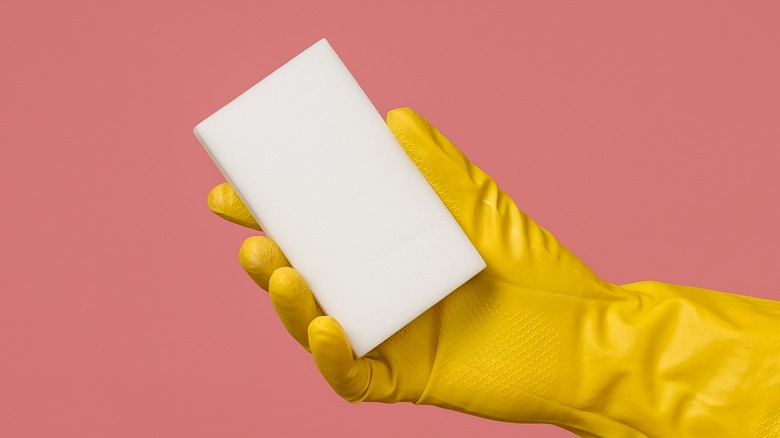 Gloved hand holding magic eraser