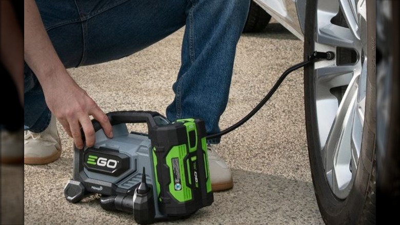 person using EGO inflator on tire