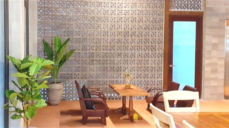 Tables and chairs in a spacious room with concrete breezeblock accent wall.