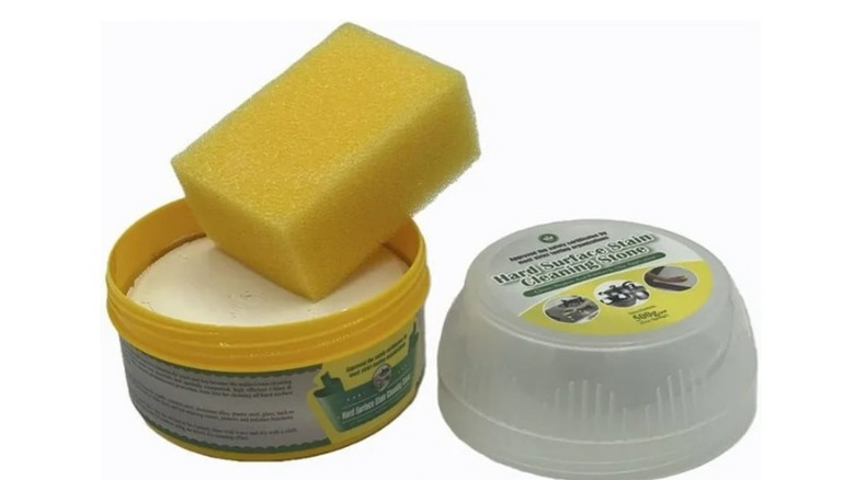 A sponge with a tub of Aquapapa Hard Surface Cleaning Paste