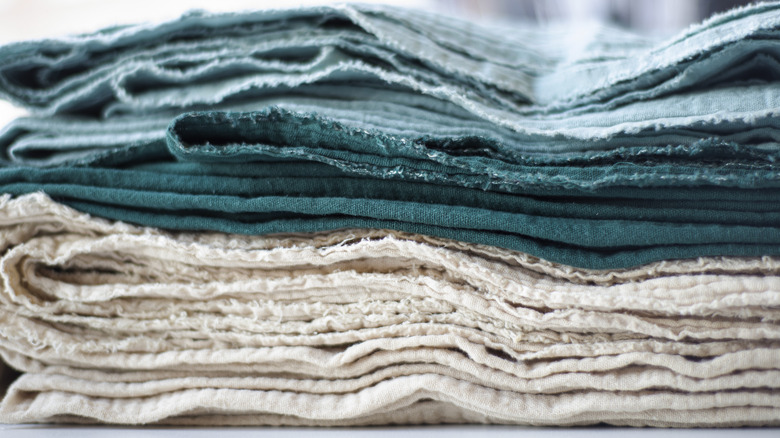 Pile of old, ragged white and blue folded towels