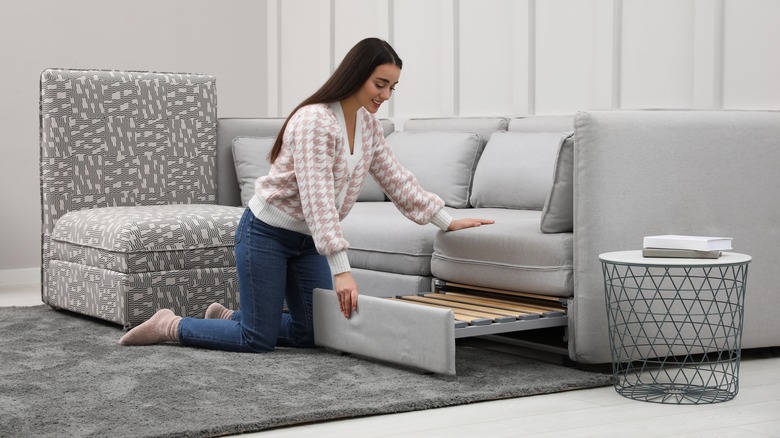 woman setting up sleeper sofa