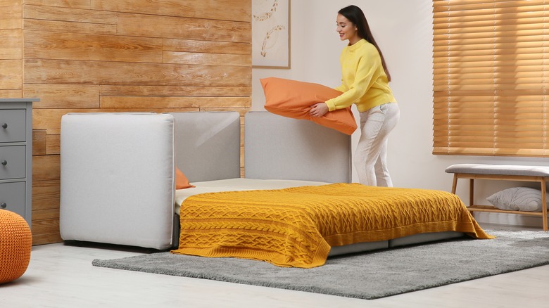 woman setting up sleeper sofa