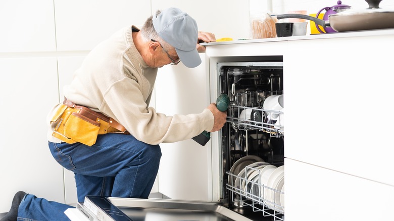 technician repairing dishwasher