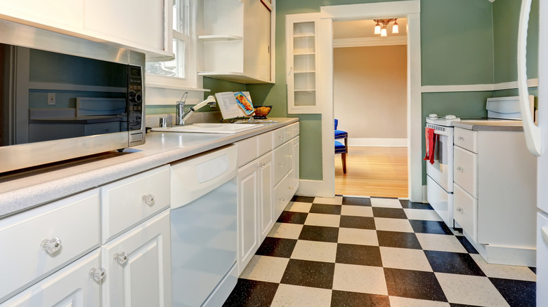 A checkerboard floor draws attention in a 1950s style kitchen with light blue walls