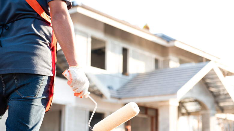 worker preparing to paint siding