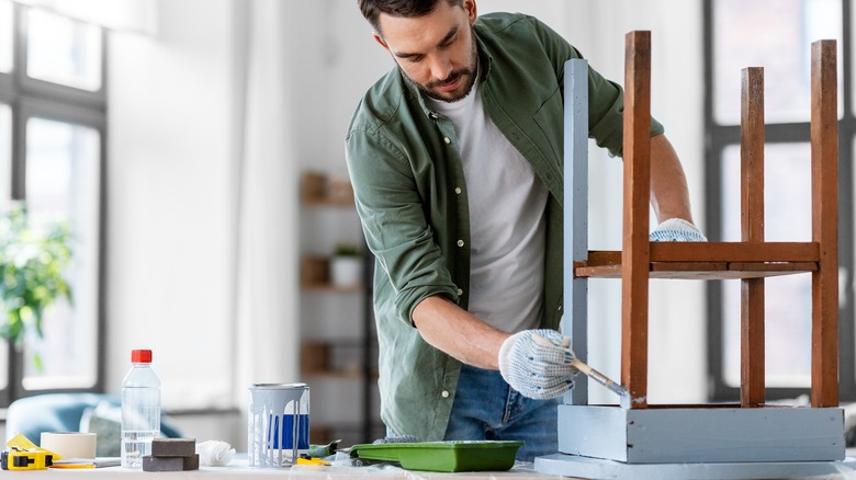 man painting old stool