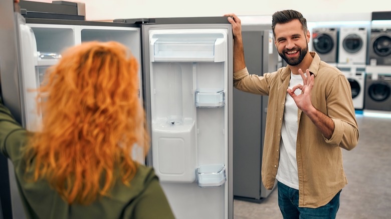 sales agent showing client fridge