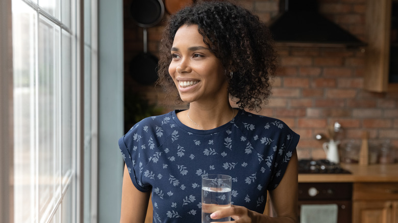 Person standing near window smiling