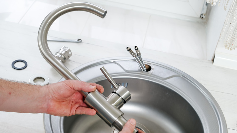 plumber holding new faucet