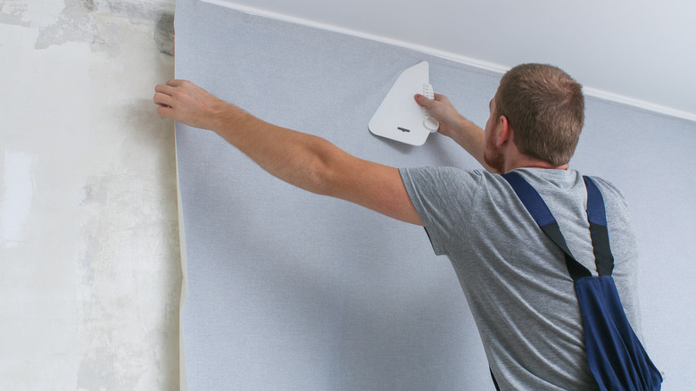 Person applying wallpaper to walls