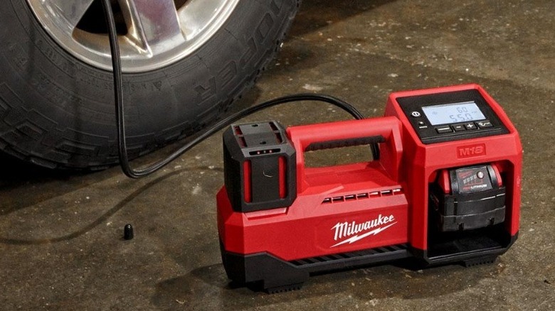Adding air to a car tire with a Milwaukee air pump