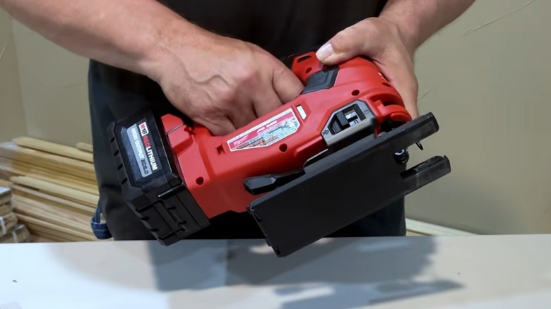 Person displaying Milwaukee M18 Fuel 18V Cordless Jigsaw in workshop