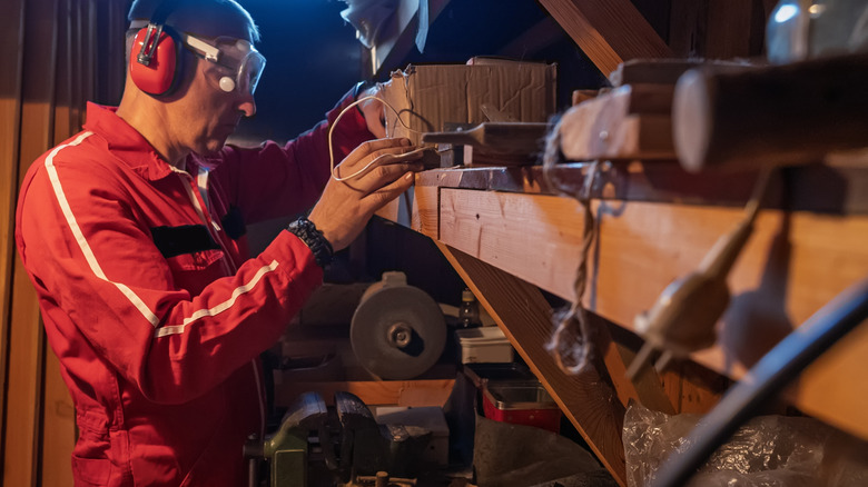 Person organizing items on shelves in a shed