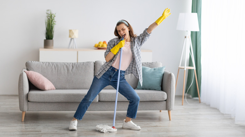 Happy lady cleaning living room