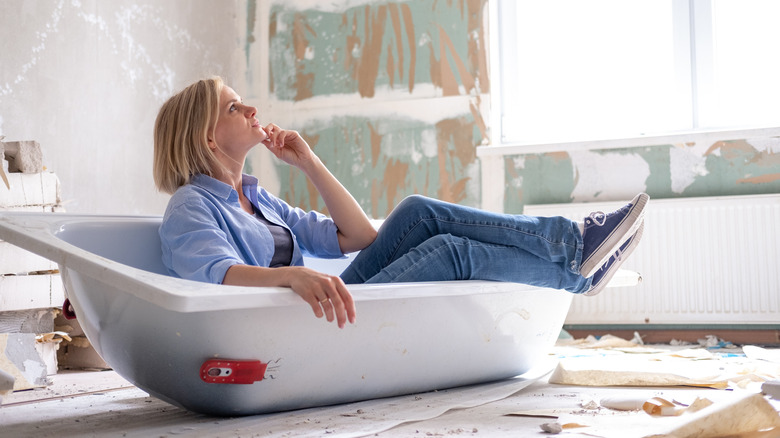 Woman sits thinking a bathtub