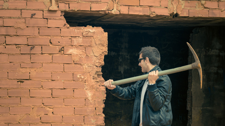 man knocking down wall