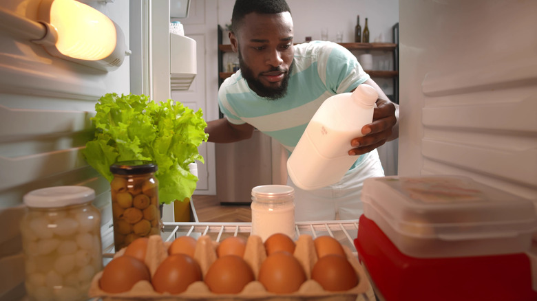 Man getting milk from refrigerator