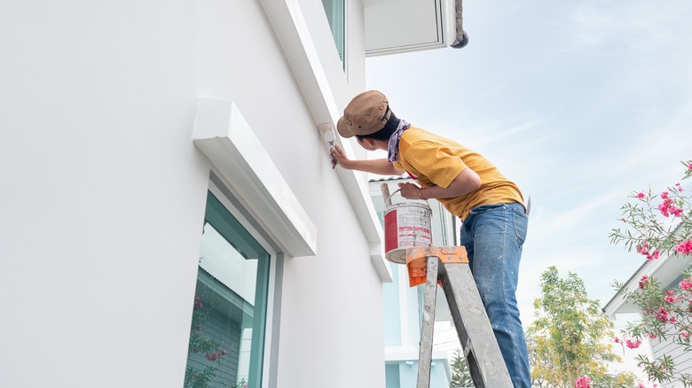 man painting house exterior