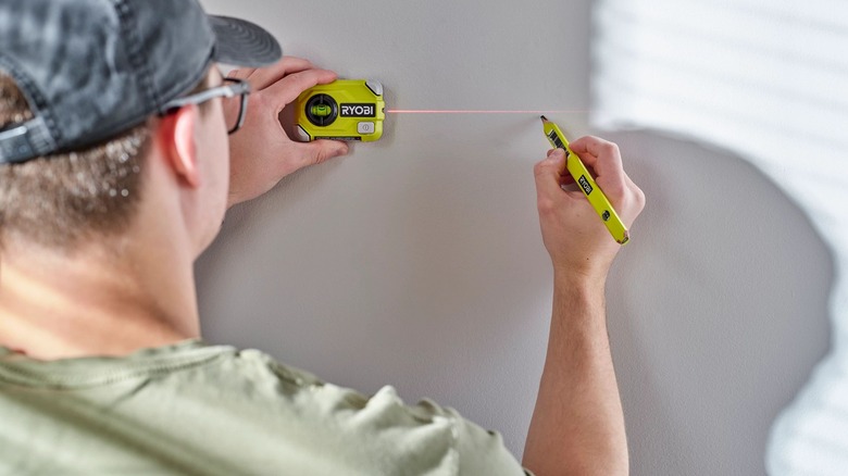 Carpenter using laser level