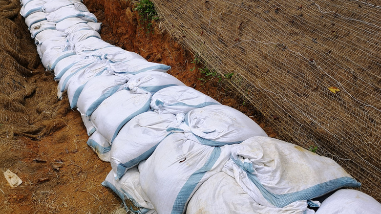 A stack of dirt bags creating a low wall on the clay