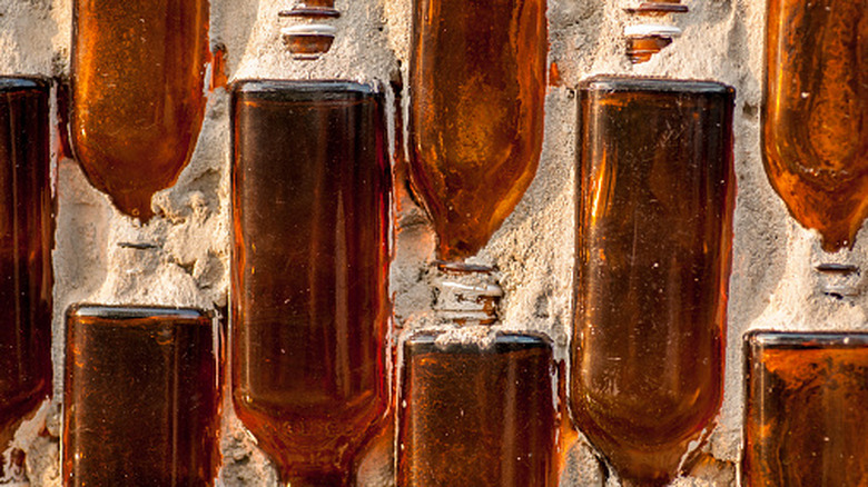 Brown glass bottles half set into a concrete structure