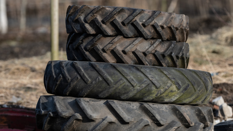 A stack of dirty old tires of different sizes