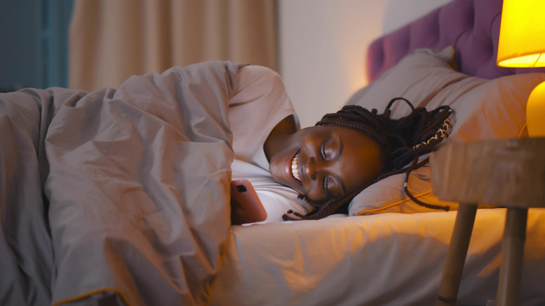 black woman smiling in bed