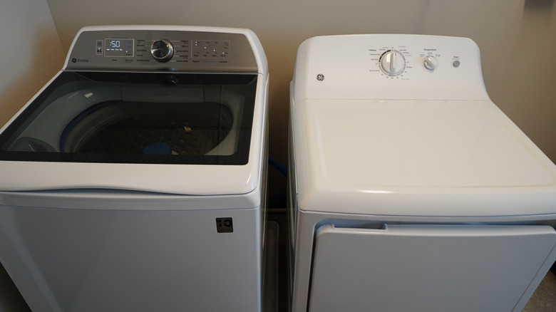 GE white washing machine and dryer sitting in a laundry room