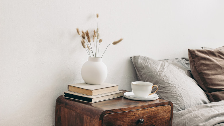 Books, vase, & cup on nightstand